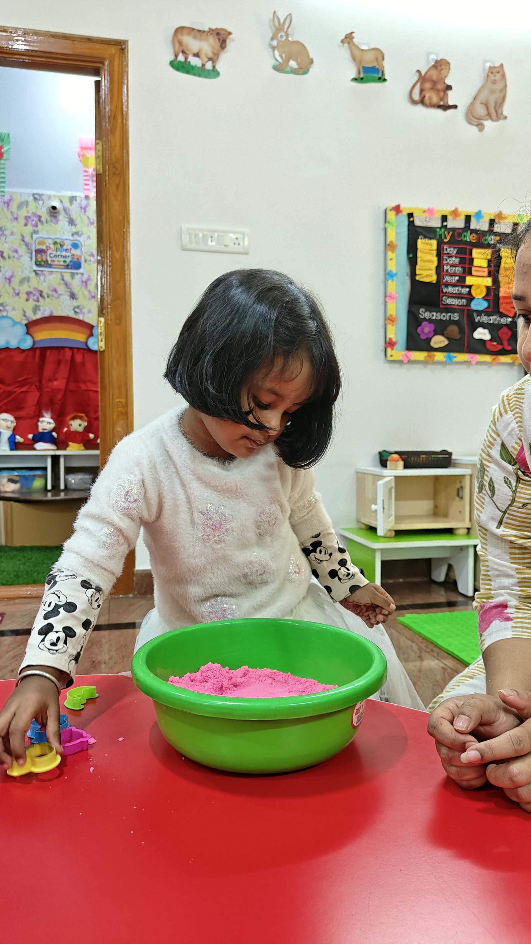 Child sorting coloured pieces at a classroom table